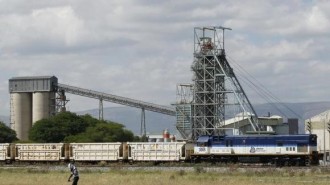 A man walks past a train carrying goods, at Anglo Platinum's Khomanani shaft 1 mine in Rustenburg