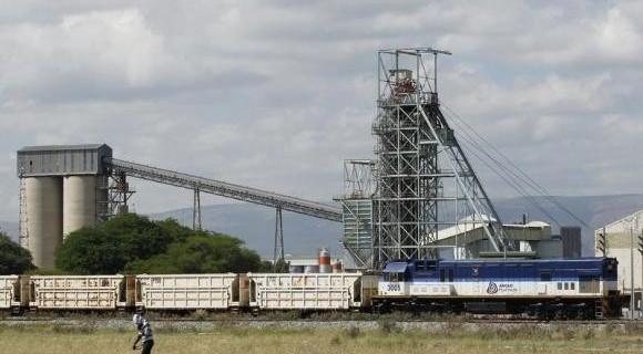 A man walks past a train carrying goods, at Anglo Platinum's Khomanani shaft 1 mine in Rustenburg