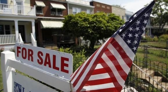 A U.S. flag decorates a for-sale sign at a home in the Capitol Hill neighborhood of Washington