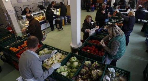 People receive food that is either too old or not looking nice enough for sale at the non-profit Dortmund food bank in the western German city of Dortmund