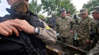 Ukraine's president, center, and Colonel-General Valery Geletey, Ukrain's defence minister, second right, examine weapons and amunition captured from pro-Russian militants, during a visit to the army's headquarters