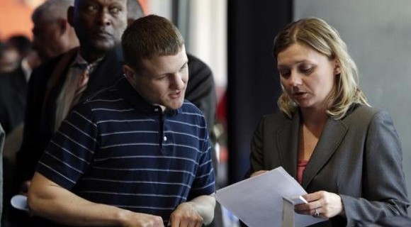 Legal firm Hogan Lovells representative Nina LeClair talks to U.S. military veteran applicant Jacob Wilkens at a hiring fair for veteran job seekers and military spouses at the Verizon Center in Washington