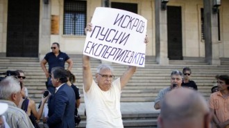 A depositor at Bulgaria's Corporate Commercial Bank (Corpbank) holds a sign during a demonstration demanding access to their accounts in Corpbank, in front of the Bulgarian National Bank in Sofia August 19, 2014. REUTERS/Pierre Marsaut