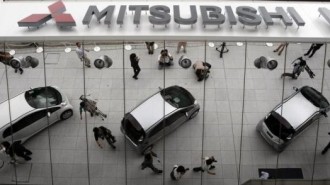 Mitsubishi Motors Corp's the i-MiEV electric vehicles are reflected on an external wall in Tokyo