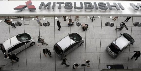 Mitsubishi Motors Corp's the i-MiEV electric vehicles are reflected on an external wall in Tokyo