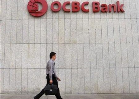 A man walks past OCBC bank in Singapore's central business district, August