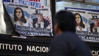 A man walks past posters with pictures of Argentina's President Cristina Fernandez de Kirchner and U.S. District Court for the Southern District of New York