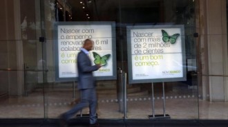 A man walks past Portuguese Novo Banco (New Bank) posters at its head office in Lisbon
