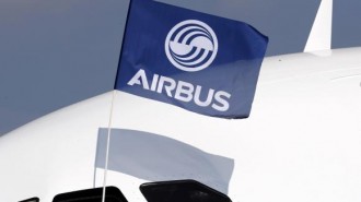 A flight test engineer holds an Airbus Group flag after the first flight of the Airbus A320neo in Colomiers near Toulouse