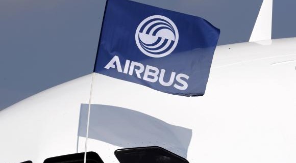 A flight test engineer holds an Airbus Group flag after the first flight of the Airbus A320neo in Colomiers near Toulouse
