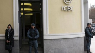 Spanish Civil Guard officers stand in front of the entrance of the headquarters of Industrial and Commercial Bank of China during a raid in Madrid