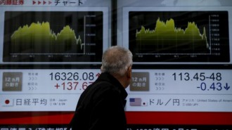 A man looks at an electronic board outside a brokerage in Tokyo