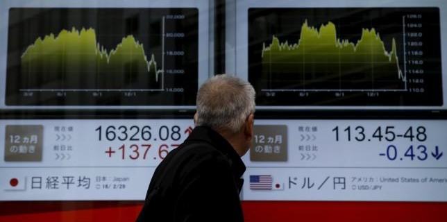 A man looks at an electronic board outside a brokerage in Tokyo