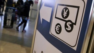 Currency signs of Japanese Yen, Euro and the U.S. dollar are seen on a board outside a currency exchange office at Narita International airport