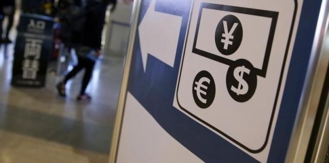 Currency signs of Japanese Yen, Euro and the U.S. dollar are seen on a board outside a currency exchange office at Narita International airport