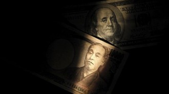 Light is cast on U.S. one-hundred dollar bill next to Japanese 10,000 yen note in Tokyo