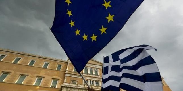 Protesters wave Greek and EU flags during a pro-Euro rally in front of the parliament building, in Athens