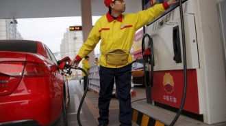 A gas station attendant pumps fuel into a customer's car at PetroChina's petrol station in Beijing