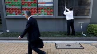 File photo of a man cleaning electronic boards outside a brokerage in Tokyo