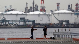 Men fish near an oil refinery in Kawasaki