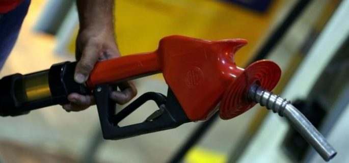 An employee holds a gas pump at a petrol station in Sao Paulo