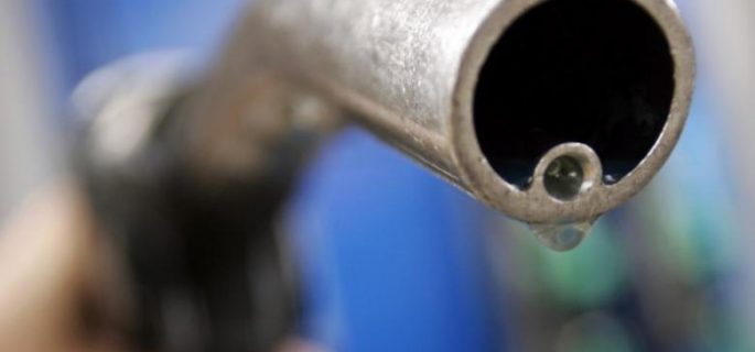 A motorist holds a fuel pump at a Gulf petrol station in London