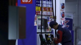 An employee of Cosmo Energy Holdings' Cosmo Oil service station checks its nozzles at a branch in Tokyo