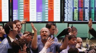 Traders gesture at each other while working in the crude oil and natural gas options pit on the floor of the New York Mercantile Exchange