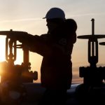 Oil prices slip back; traders await OPEC report