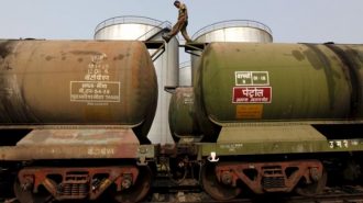 FILE PHOTO: A worker walks atop a tanker wagon to check the freight level at an oil terminal on outskirts of Kolkata