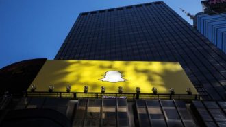 A billboard displays the logo of Snapchat above Times Square in New York