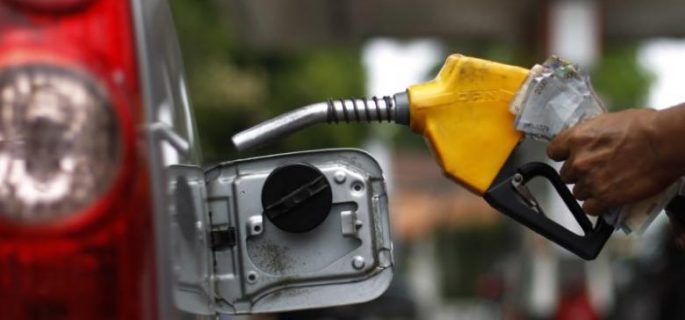 A worker fills a tank with subsidized fuel at a fuel station in Jakarta