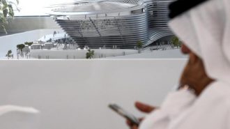 A man uses his mobile device next to a model of the Expo 2020 project in Dubai, United Arab Emirates, April 3, 2017. REUTERS/Stringer - RTX33UGT