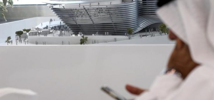 A man uses his mobile device next to a model of the Expo 2020 project in Dubai, United Arab Emirates, April 3, 2017. REUTERS/Stringer - RTX33UGT
